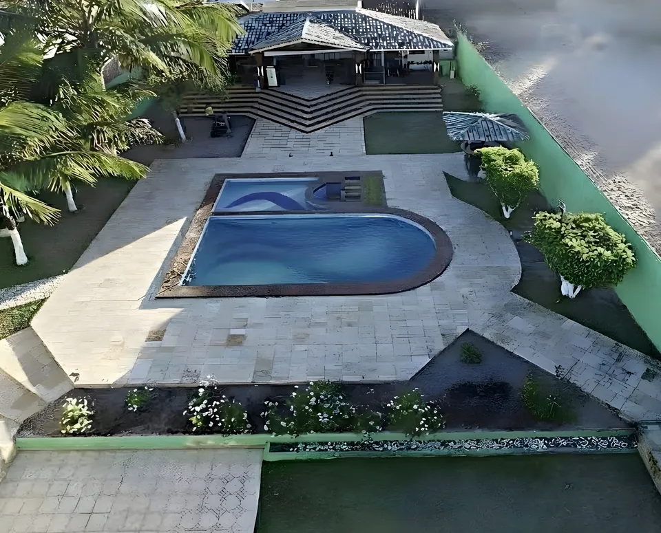 Área de lazer vista de cima, com piscina adulto e infantil, gramado e varanda ao fundo